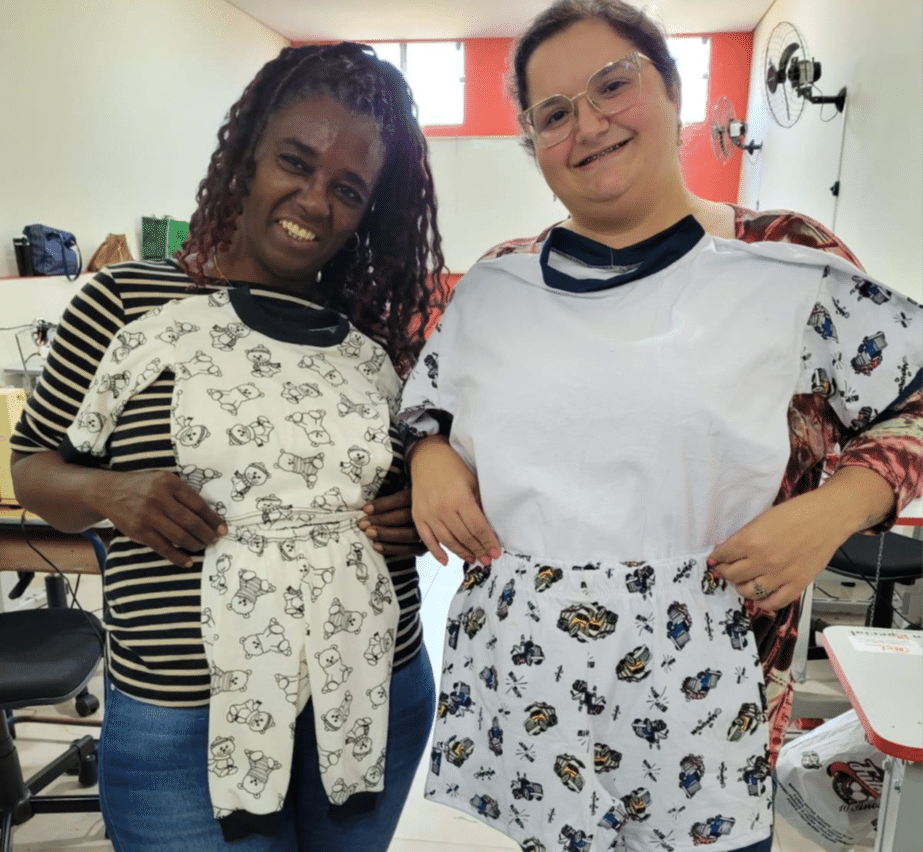Brazil - two women holding pajamas they sewed